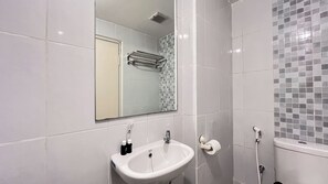 A bathroom with a white sink, a mirror, and a shower. - Homey And Restful Studio At Tokyo Riverside Pik 2 Apartment (Teluknaga)
