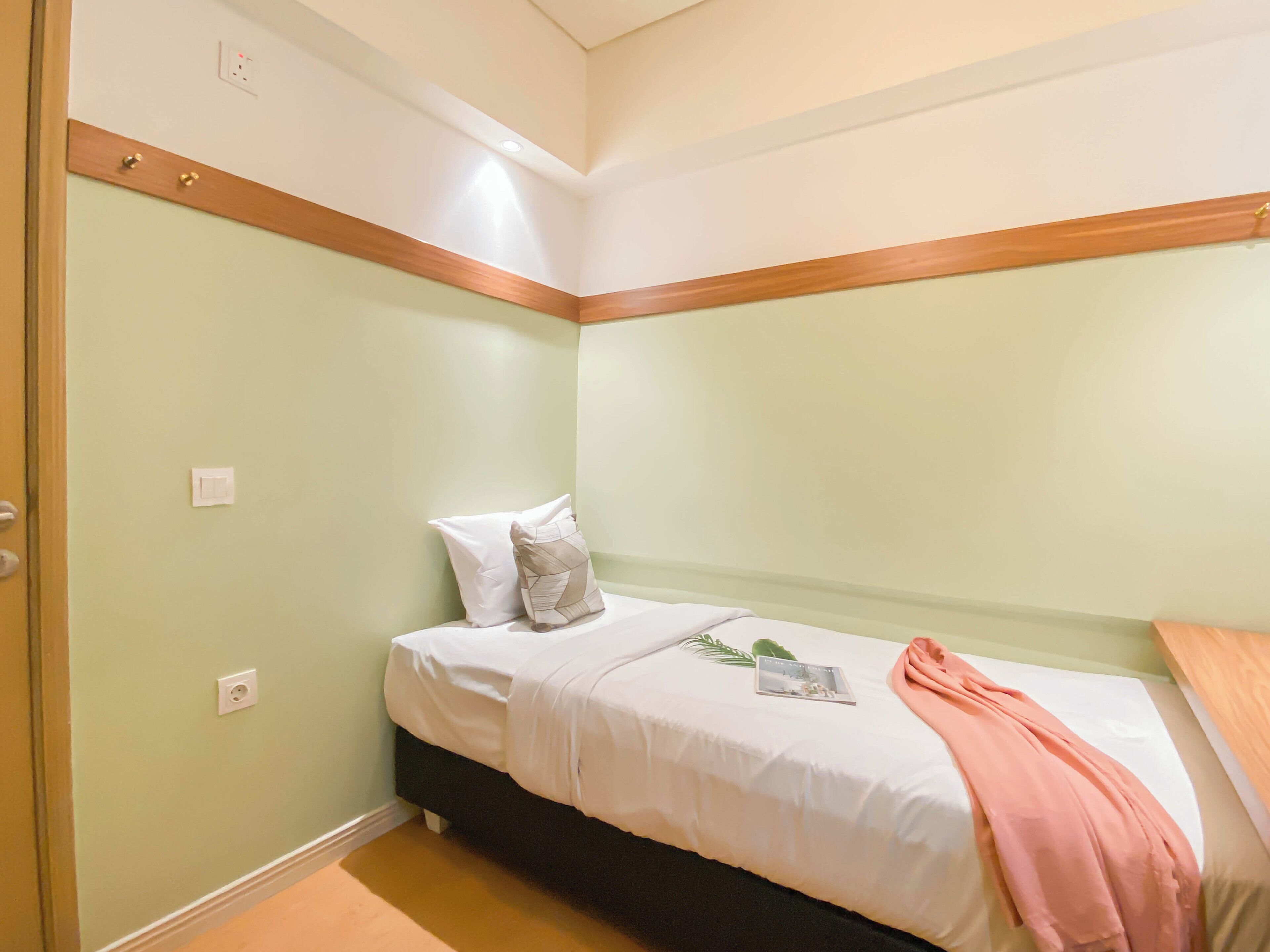 A bedroom with a bed, pillows, a bedside table, and a nightstand.