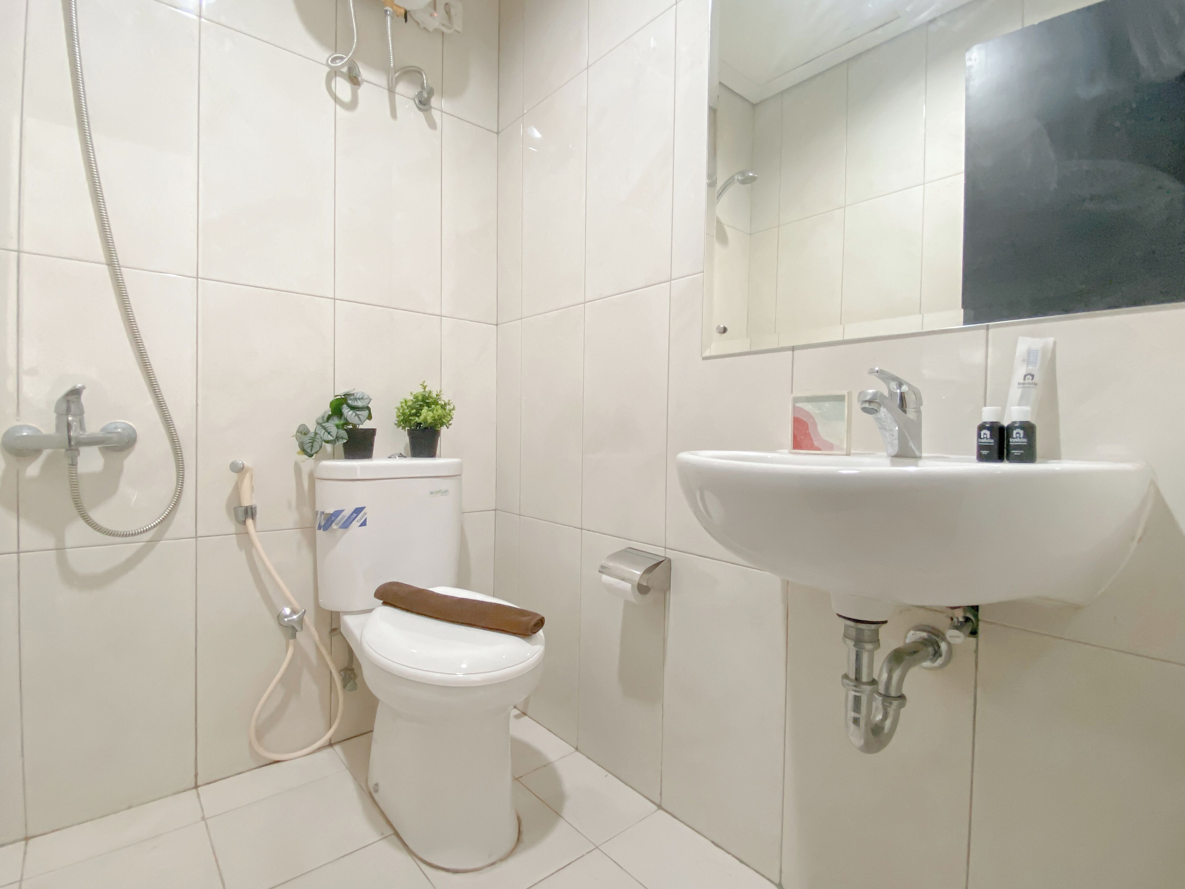 Een moderne badkamer met toilet, douche en wastafel.