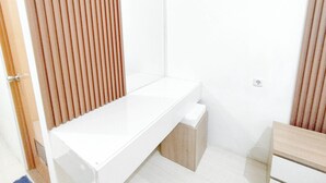 Een moderne badkamer met een wit wastafelmeubel, houten jaloezieën en een betegelde vloer.