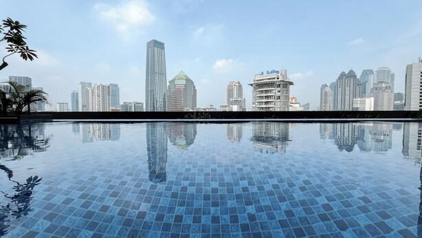 Une piscine avec une vue sur la ville en arrière-plan.