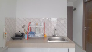 Una cocina con estufa, lavaplatos y escurreplatos.