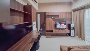Una sala de estar moderna con un mueble de entretenimiento de madera, un televisor de pantalla plana y una cafetera.