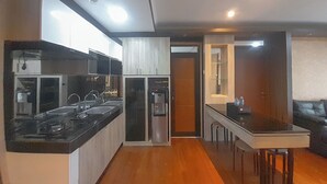 Una cocina moderna con electrodomésticos de acero inoxidable, una encimera de madera y un refrigerador empotrado.