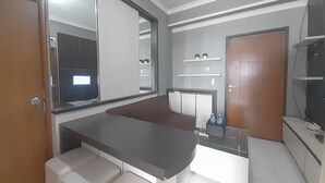 A modern bathroom with a large mirror, a vanity with a sink, and a shower area.