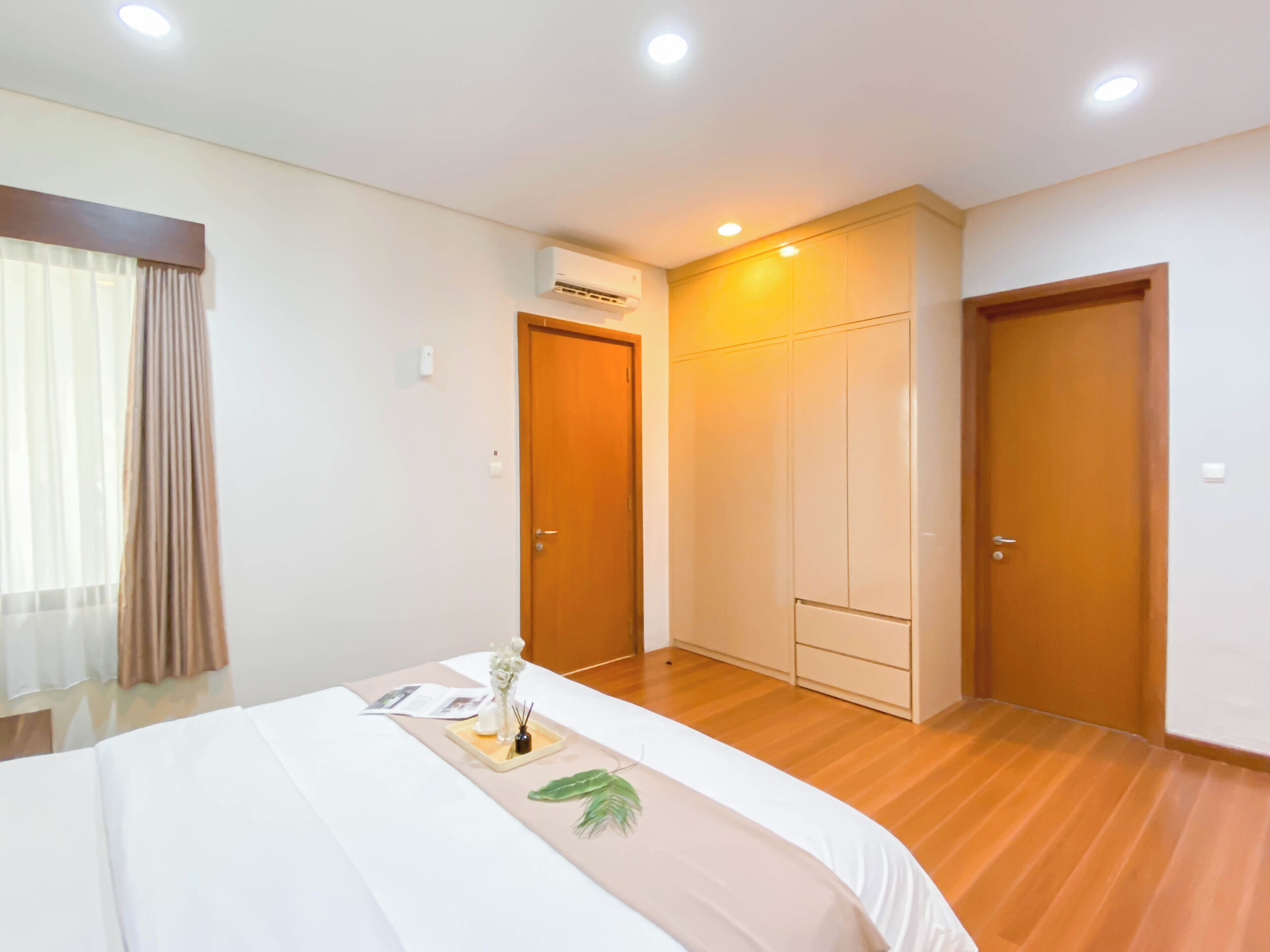 Una habitación de hotel con una cama, un armario, una puerta y un equipo de aire acondicionado.