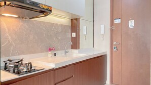 A modern kitchen with a gas stove, sink, and wooden cabinets.