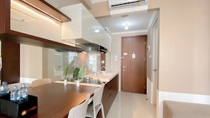 A modern kitchen with a wooden island, white chairs, and a black water cooler.