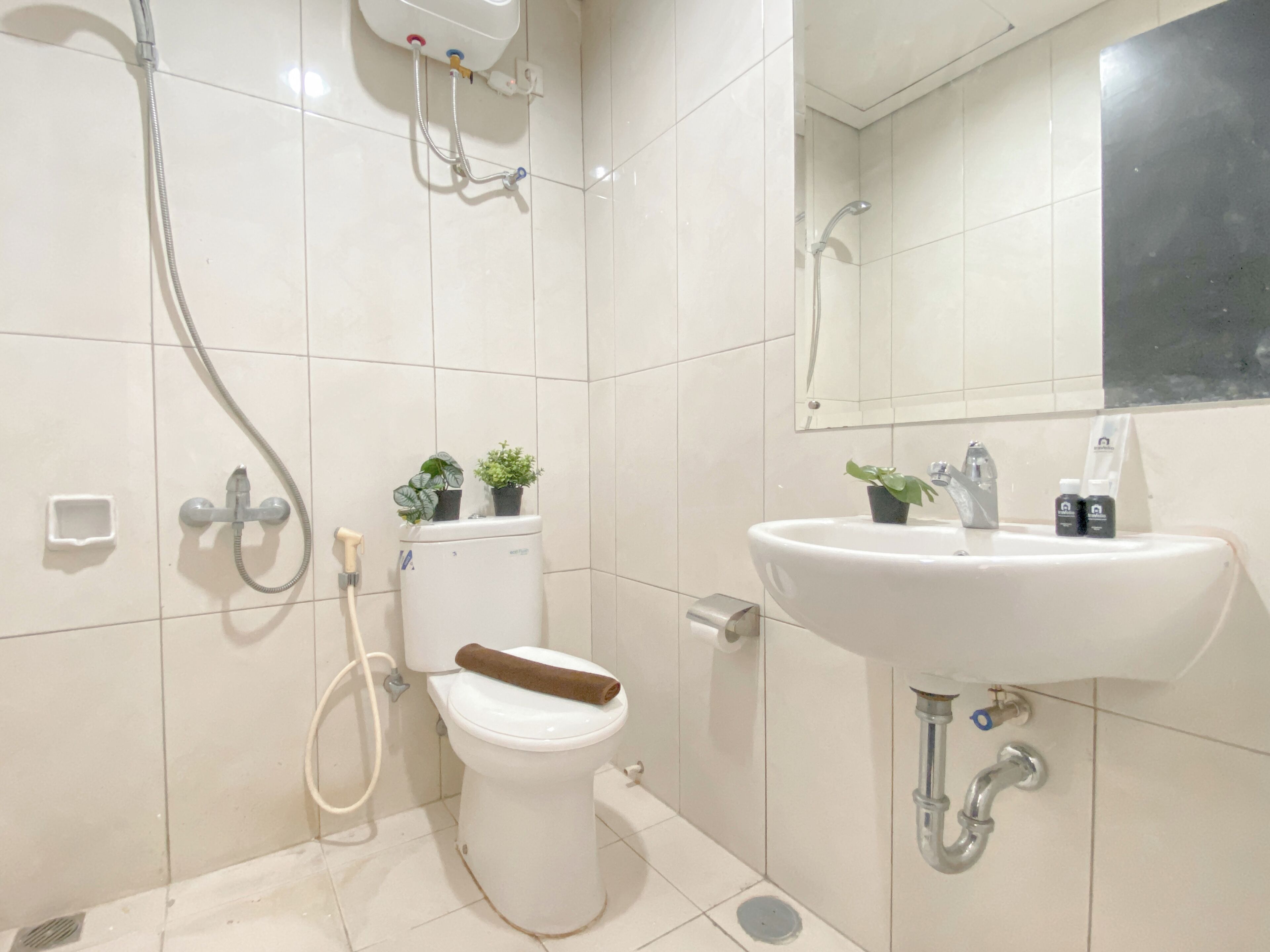 A modern bathroom with a toilet, bidet, sink, and a mirror.