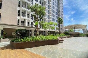 Un hotel moderno con un patio espacioso, varios balcones y abundante vegetación.