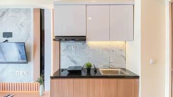 A compact kitchen with a built-in oven, a sink, and a small countertop.