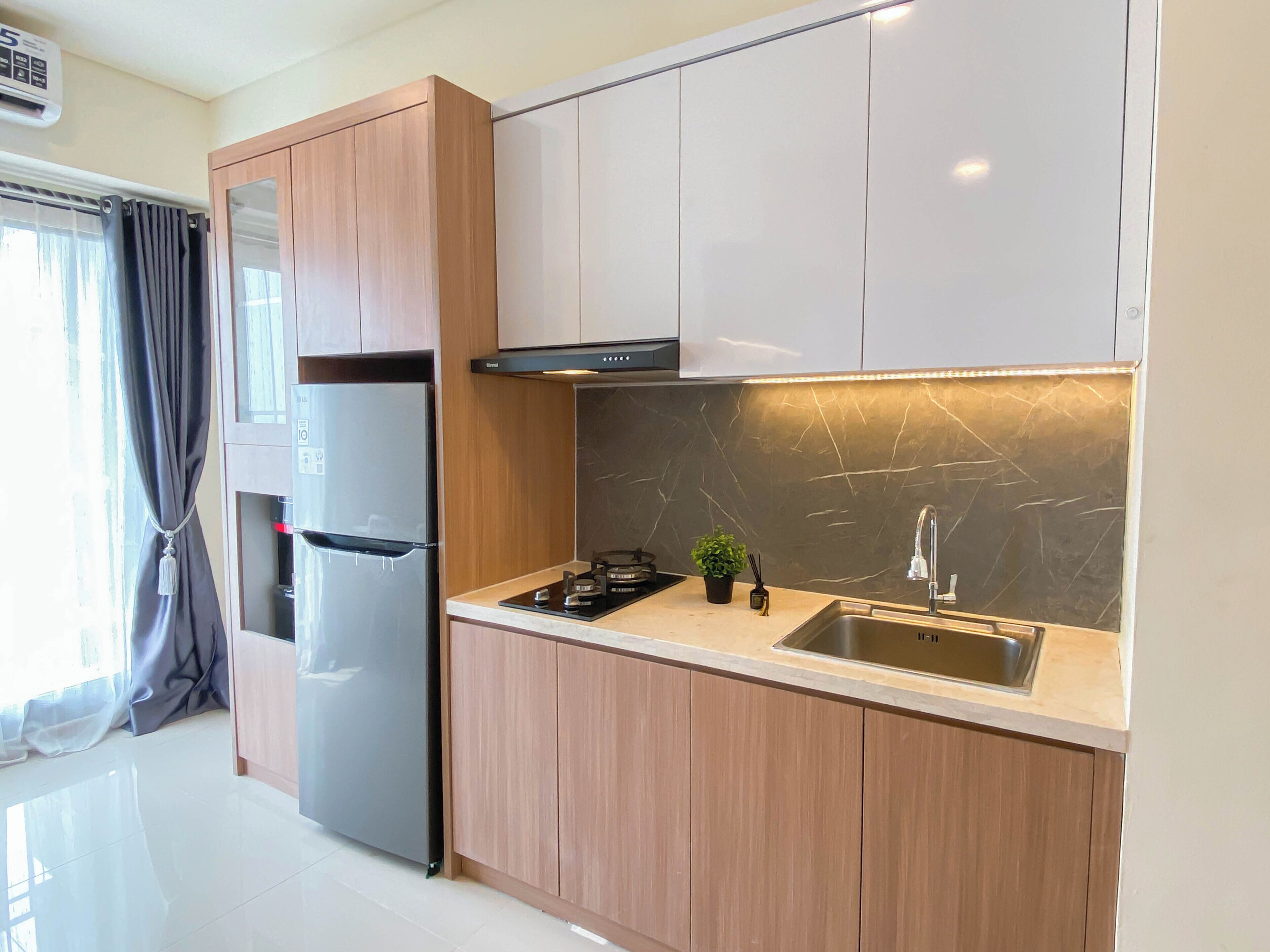 A modern kitchen with wooden cabinets, a stainless steel sink, and a built-in oven.