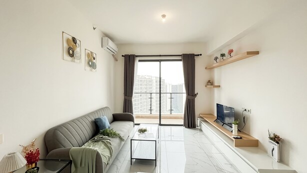 A modern living room with a sofa, coffee table, and TV.