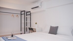 A modern hotel room with a bed, a desk, and a chair. - Spacious And Homey Studio Loft At Kingland Avenue Apartment (South Tangerang)