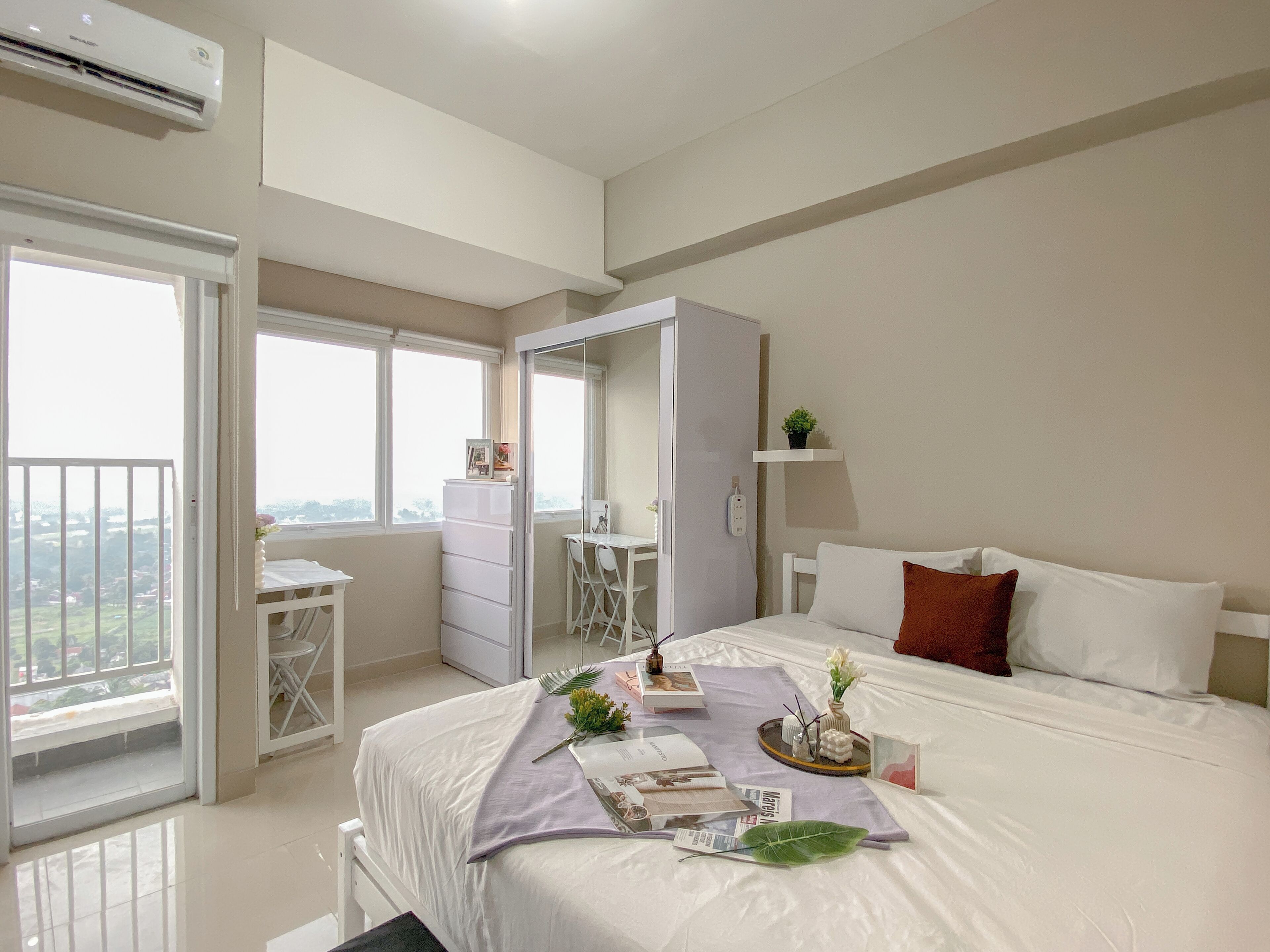 A bedroom with a bed, a desk, and a wardrobe.