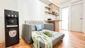 A compact living space with a sofa, a small kitchenette, and a refrigerator. - Warm And Comfy 2Br At Bassura City Apartment (Jakarta)