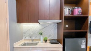 A compact kitchen with a sink, a stove, and a refrigerator.