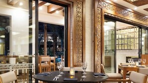 A dining area with a round table, four chairs, and a decorative wall panel. - Charming 1-bedroom villa beach front, Thanksgiving week in San José del Cabo (San José del Cabo)