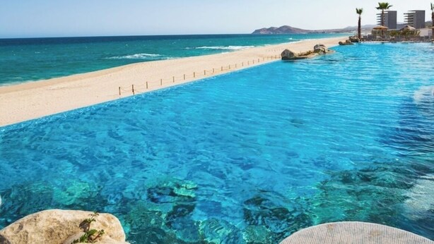 A clear blue pool with a sandy beach and a view of the ocean. - Charming 1-bedroom villa beach front, Thanksgiving week in San José del Cabo (San José del Cabo)