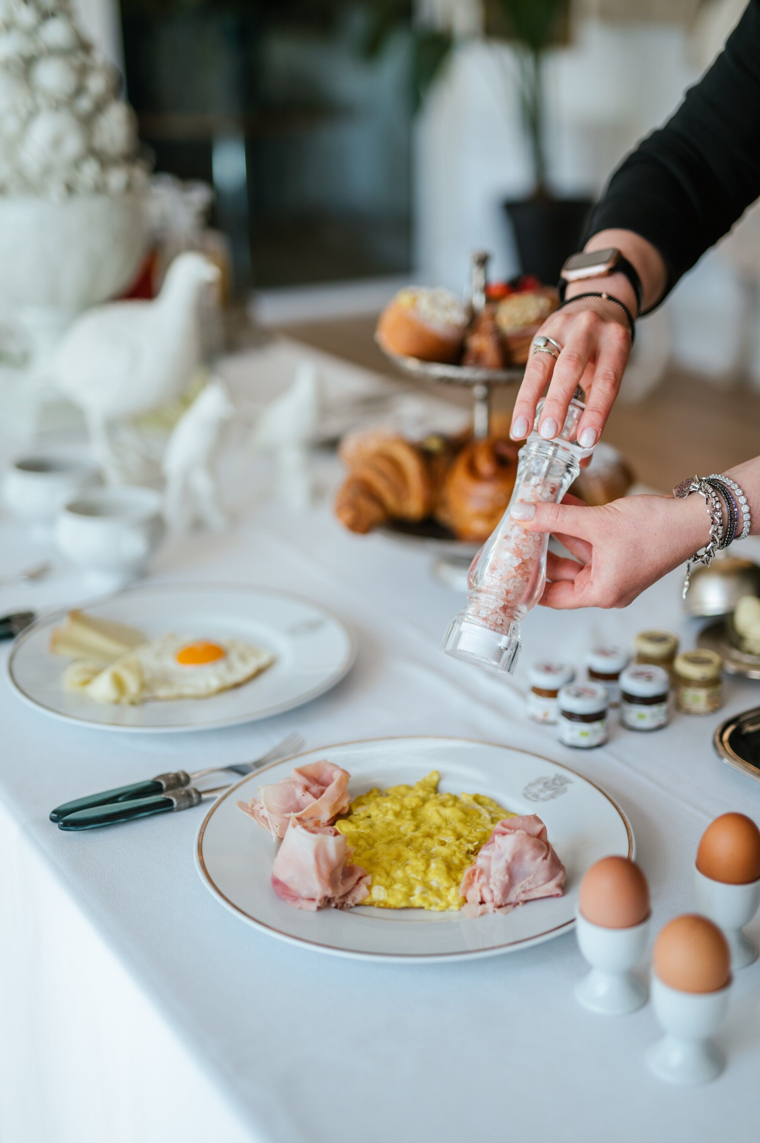 Ein Frühstückstisch mit Speisen, einem Salzstreuer und Eiern.
