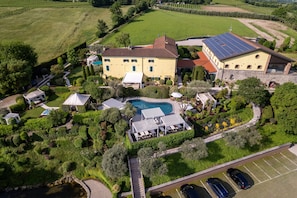 A large estate with a swimming pool, multiple buildings, and a parking area.