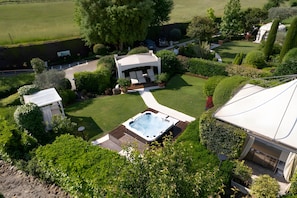 A private garden with a hot tub, a gazebo, and a swimming pool.