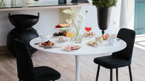 A dining table with chairs, a vase with flowers, and a potted plant. - Room 'Casino Di Caccia 6' with Shared Pool, Wi-Fi and Air Conditioning (Sommacampagna)