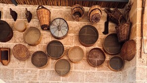A stone bench with cushions, surrounded by various woven baskets and containers on a stone wall. - King Room with Jacuzzi - Charming in Felline - Borgo Don Ciccio (Felline)