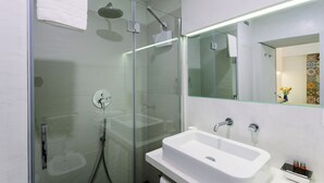 A modern bathroom with a glass-enclosed shower, a white sink, and a mirror above the sink. - 1743LOft Cortiletto (Siracusa)