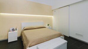 A modern bedroom with a bed, bedside tables, and a wardrobe. - 1743LOft Cortiletto (Siracusa)
