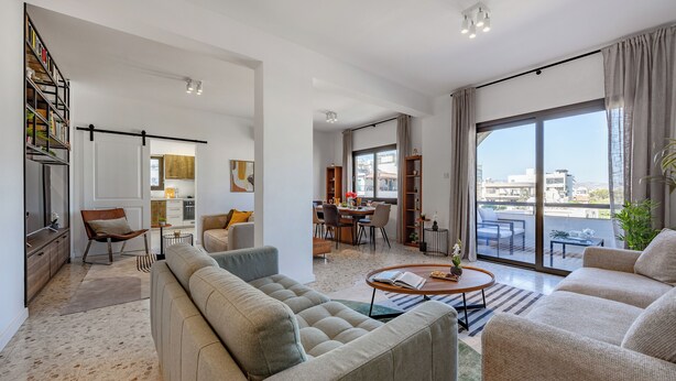 A modern living room with a sofa, coffee table, and bookshelves.