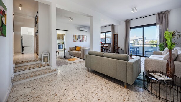 Una sala de estar moderna con un sofá, una mesa de centro y un ventanal con vistas.