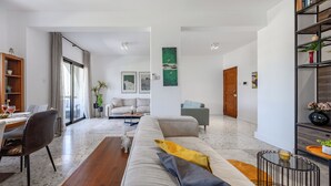 Una sala de estar moderna con sofá, mesa de centro y comedor con sillas y una mesa.