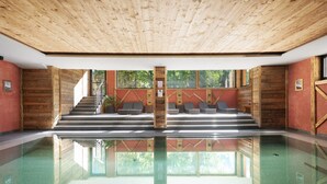 A pool area with wooden walls, a glass floor, and a staircase leading to a seating area. - Apartment 'Hotel Residence Olympia 4' with Mountain View, Shared Garden and Wi-Fi (Sarnthein)