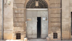 A stone building entrance with a metal gate, a sign reading 'PASSO CARRABILE,' and a number '25' on the wall. - Attica B&B – 'Red' Room with Shared Terrace, Wi-Fi, and Air Conditioning (Terlizzi)