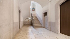 A hallway with a staircase, white walls, and a brown door. - Attica B&B – 'Red' Room with Shared Terrace, Wi-Fi, and Air Conditioning (Terlizzi)