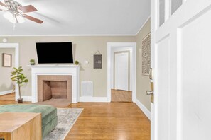 A living room with a fireplace, a television, and a ceiling fan. - Spacious Stay w 2 King Beds Minutes to Downtown (Greenville)