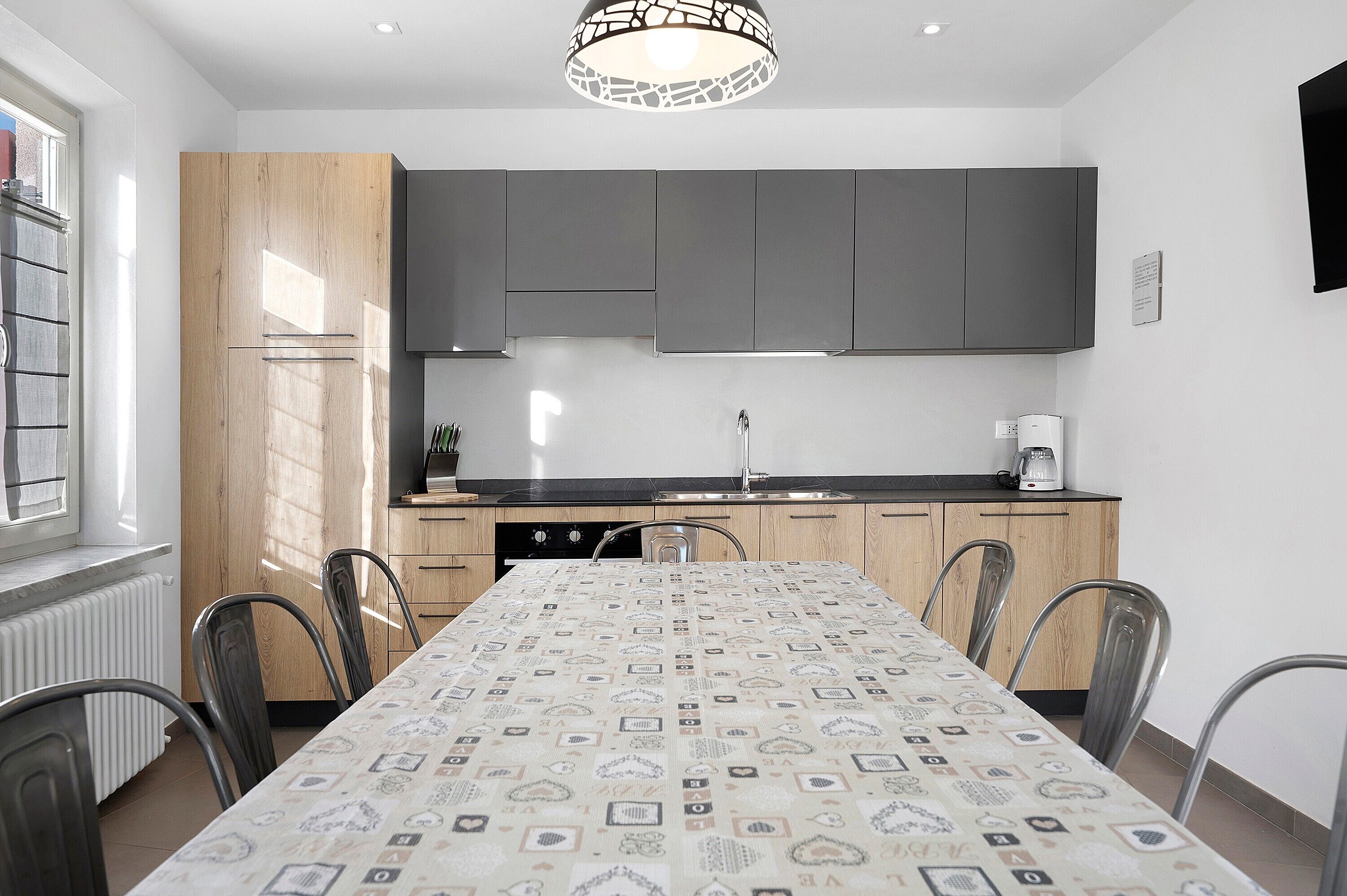 Une cuisine moderne avec une table à manger, des chaises et un réfrigérateur.