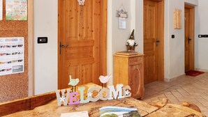A reception area with a cork bulletin board, wooden doors, a welcome sign, and a gnome decoration.