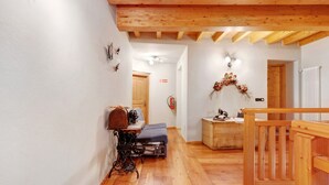 A wooden interior with a bench, a sewing machine, and a decorative wreath.