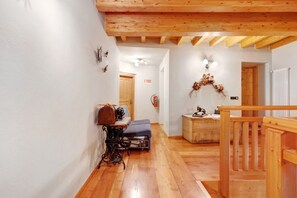 A wooden interior with a bench, a sewing machine, and a decorative wreath.