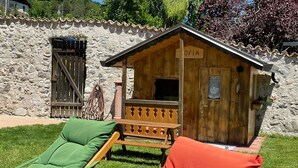 A rustic wooden building with a sign reading 'OfIA' and a small porch.