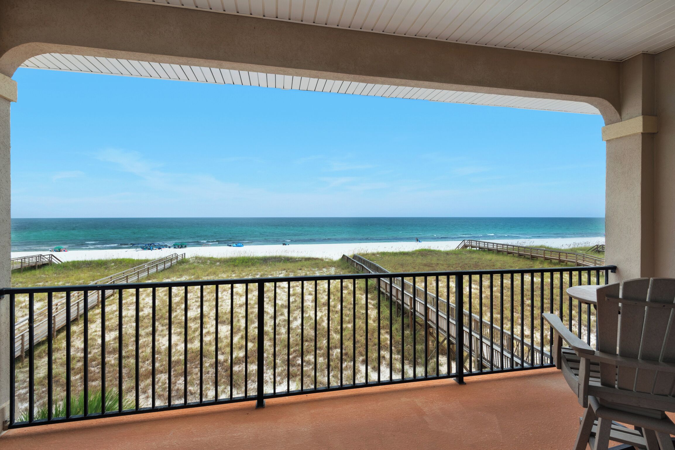 A balcony with a view of the beach and ocean.