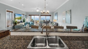 A modern kitchen with granite countertops, stainless steel sinks, and a large island. - Navarre Beachfront Townhome Southern Cross Sleeps 13 + Pet Friendly (Navarre)