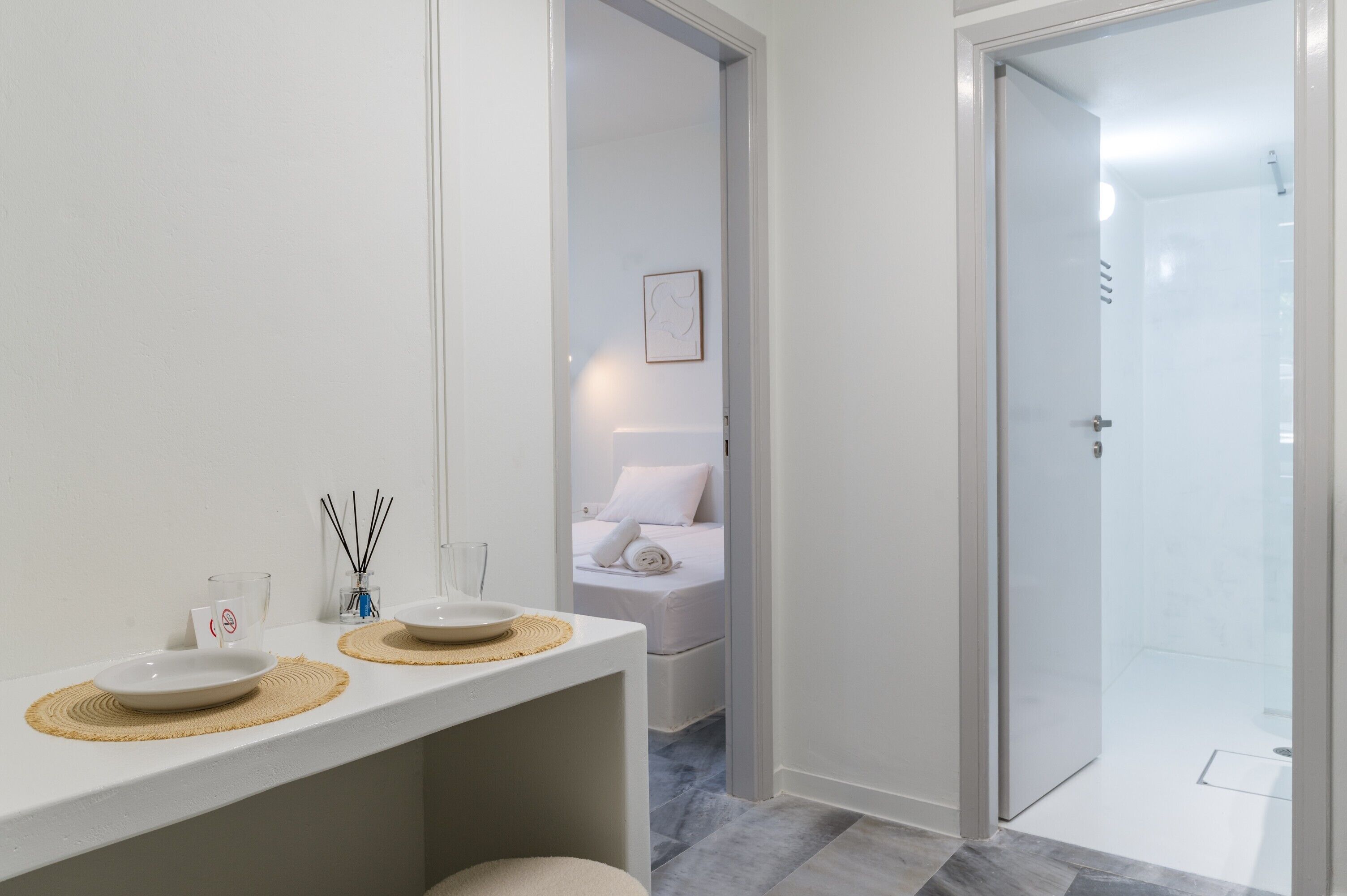 Uma casa de banho moderna com um lavatório branco, uma tigela de vidro e um quadro na parede.