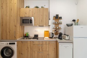 Una cocina moderna con armarios de madera, microondas integrado, cafetera y lavavajillas.