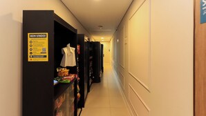 Ein Hotelgang mit einem Verkaufsautomaten links, einer Büste in einem weißen Kleid und einem Schild mit Zahlungsoptionen.