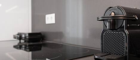 A modern kitchen with a black coffee machine on a sleek countertop.