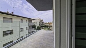 Ein Balkon mit Blick auf benachbarte Gebäude und einen klaren Himmel.