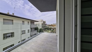 A balcony with a view of neighboring buildings and a clear sky. - Modern Flat With Terrace in Bibione (San Michele al Tagliamento)